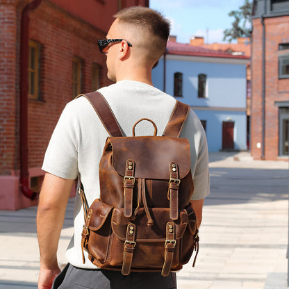 Man wearing a brown leather backpack in an urban setting
