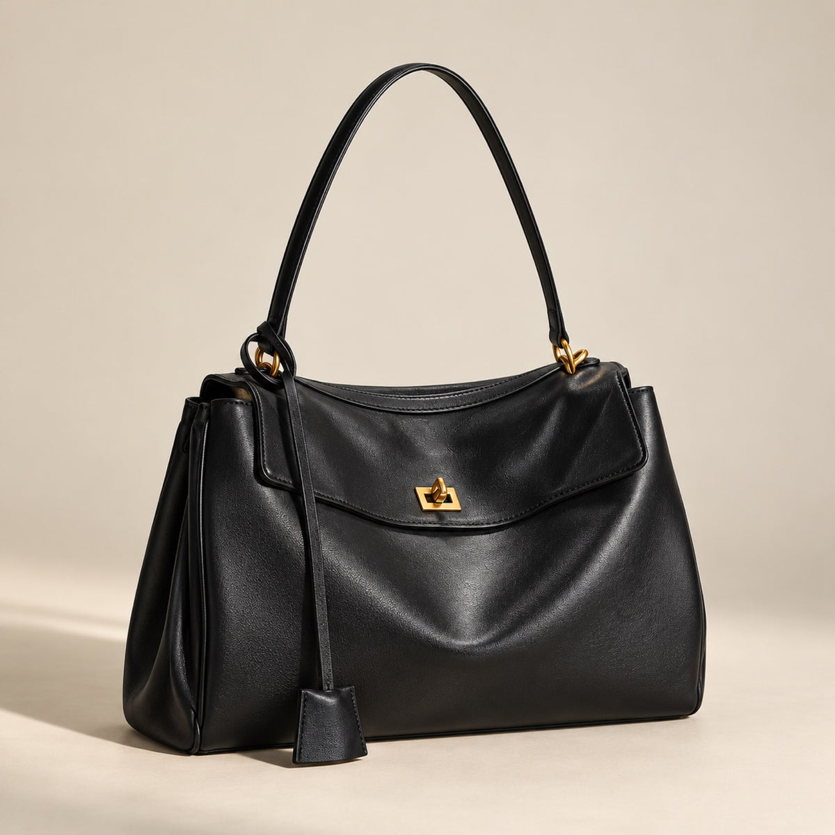 Kensington leather shoulder bag in black with gold hardware, three-quarter view showing depth