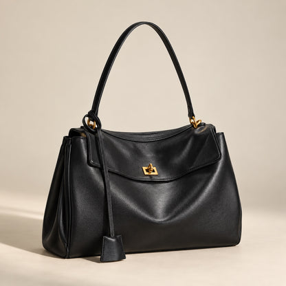 Kensington leather shoulder bag in black with gold hardware, three-quarter view showing depth
