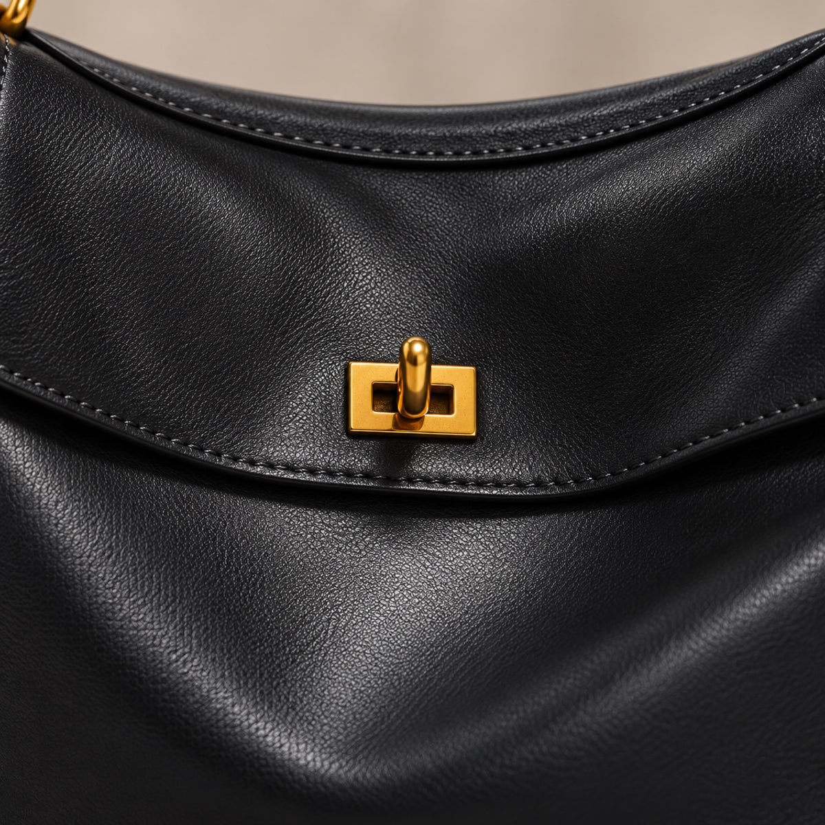 Close-up of the gold twist-lock and stitched flap on the Kensington leather bag